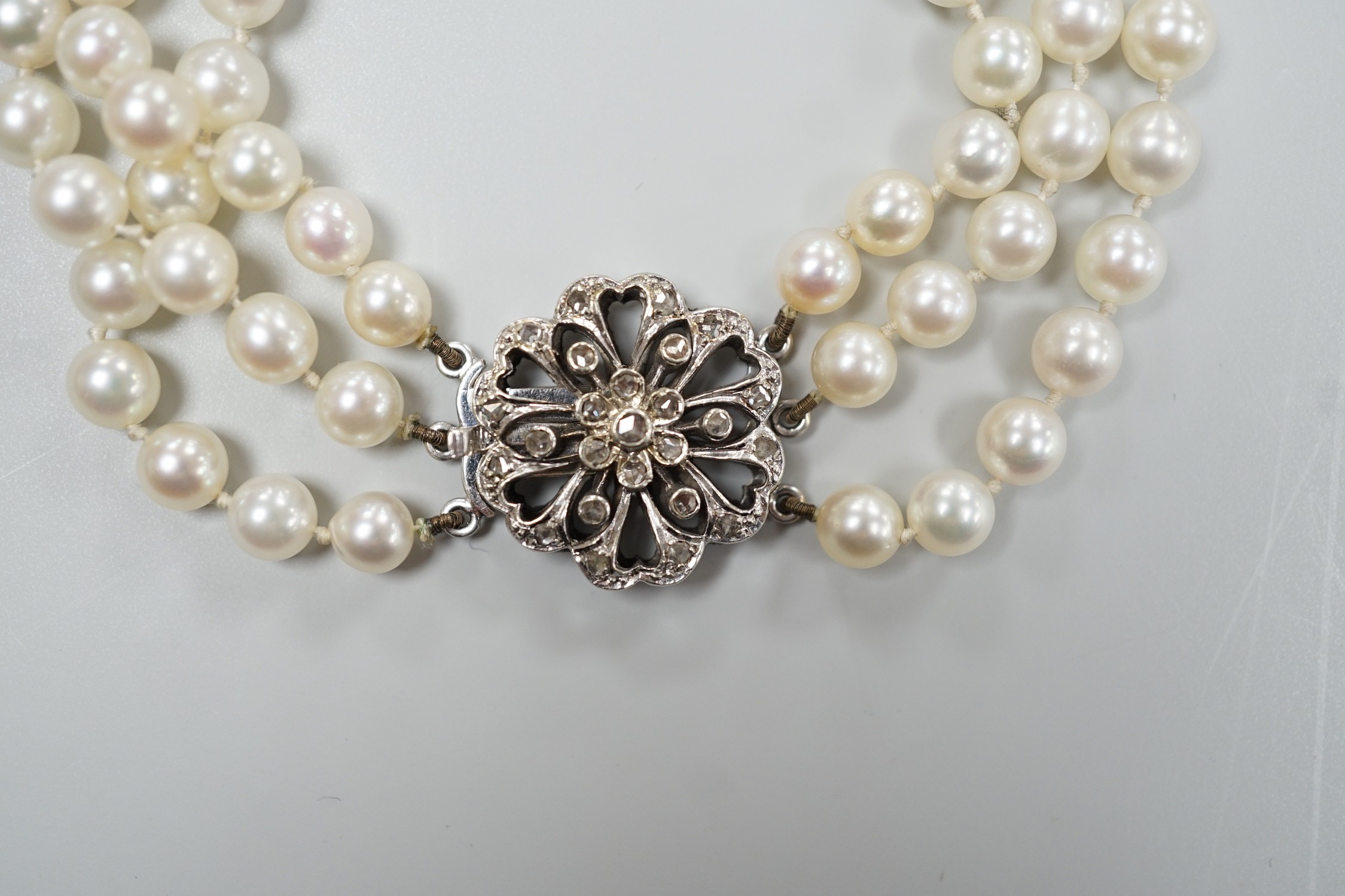 A 1960's triple strand cultured pearl bracelet, with 9ct white gold and diamond chip set clasp, 20cm.